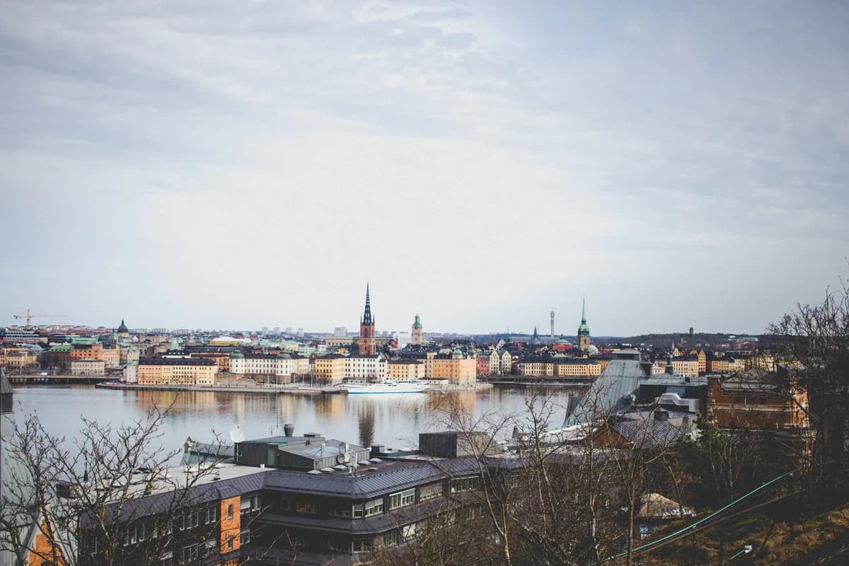 Stockholm's Old Town skyline across the water on a cloudy day, with church spires above the historic waterfront